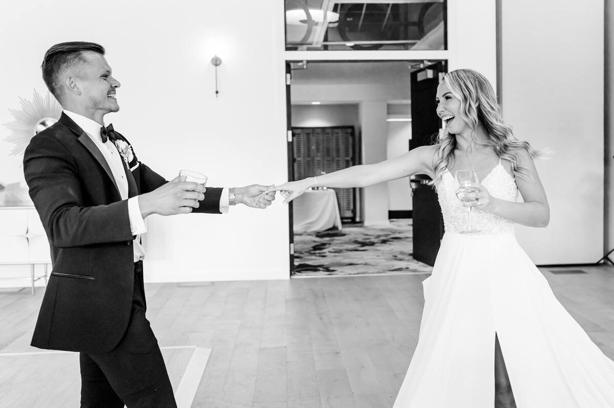 groom pulls bride in for a twirl during grand entrance