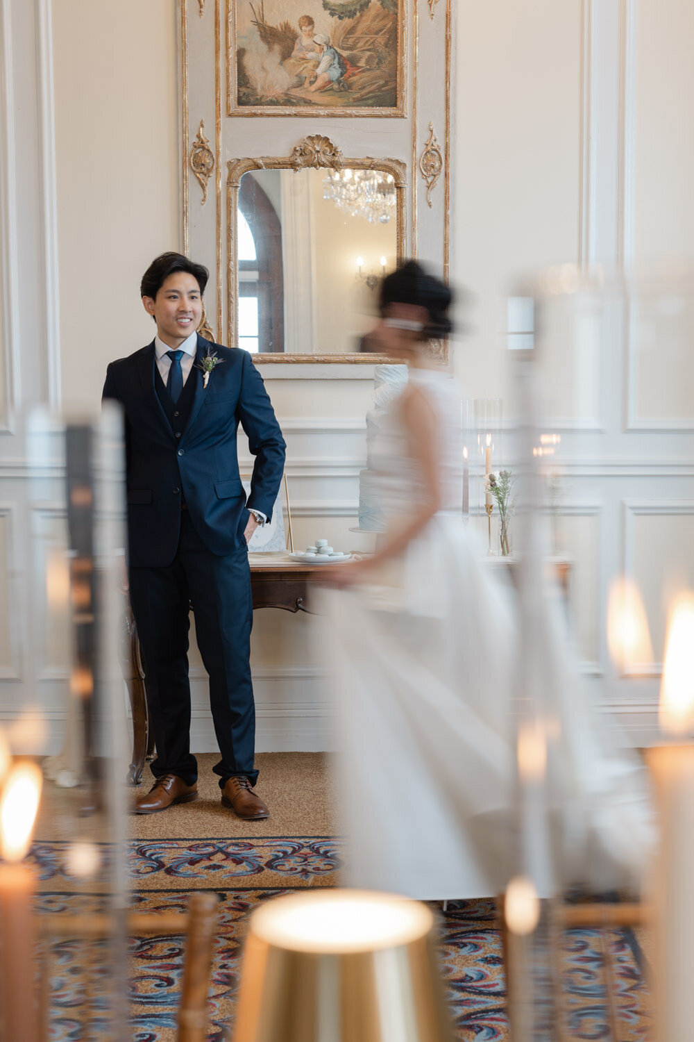 Image éditoriale d’un mariage asiatique où la mariée, en mouvement et légèrement floue, marche devant son époux, scène artistique et contemporaine capturée avec une touche cinématographique
