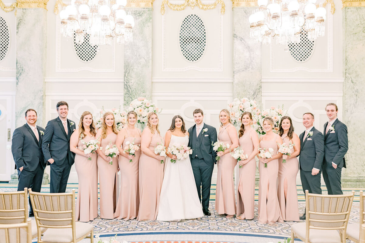Bride and groom with bridal party in ballroom.