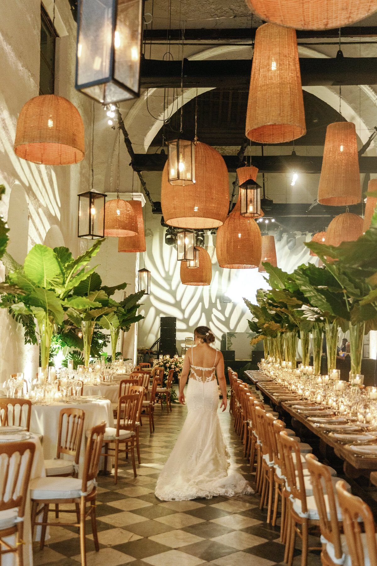 Bride walking into a beautifully decorated reception hall with hanging lanterns, photographed by Claudia Amalia Photography in Miami, Florida.