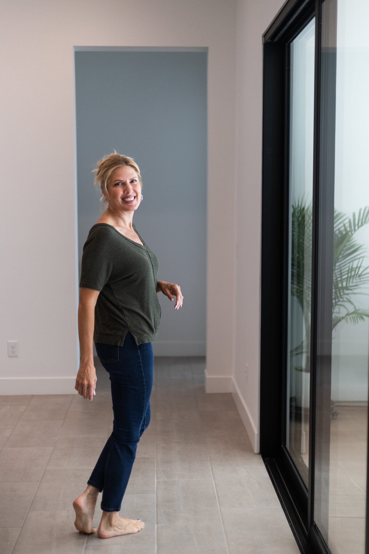 Laura Bogart at home in front of sliding glass doors