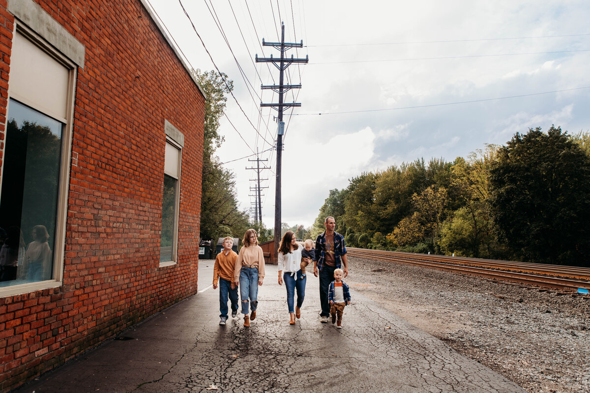Family walks along brick wall in grand Pacific Junction.