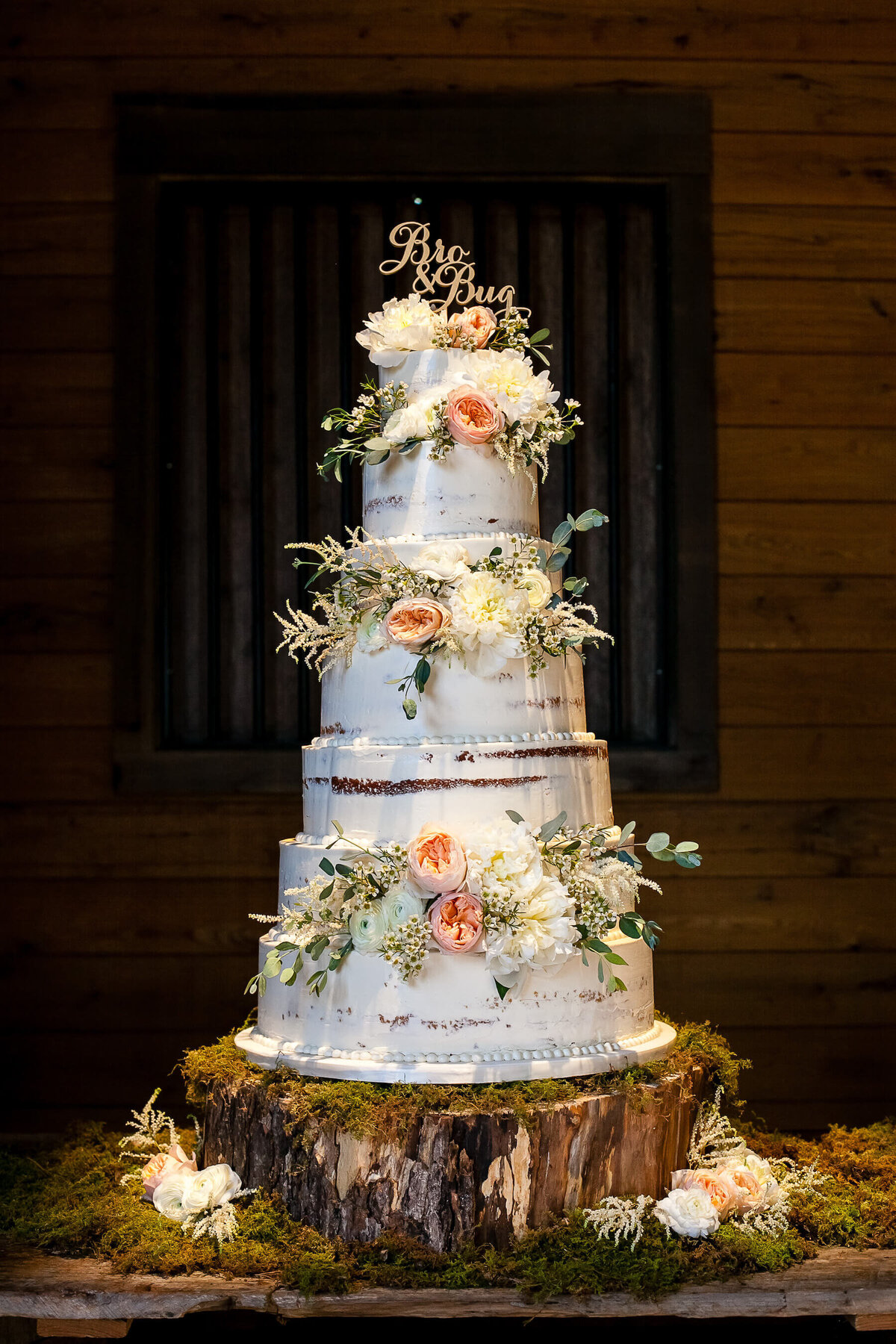 rustic naked wedding cake with pink roses and greenery