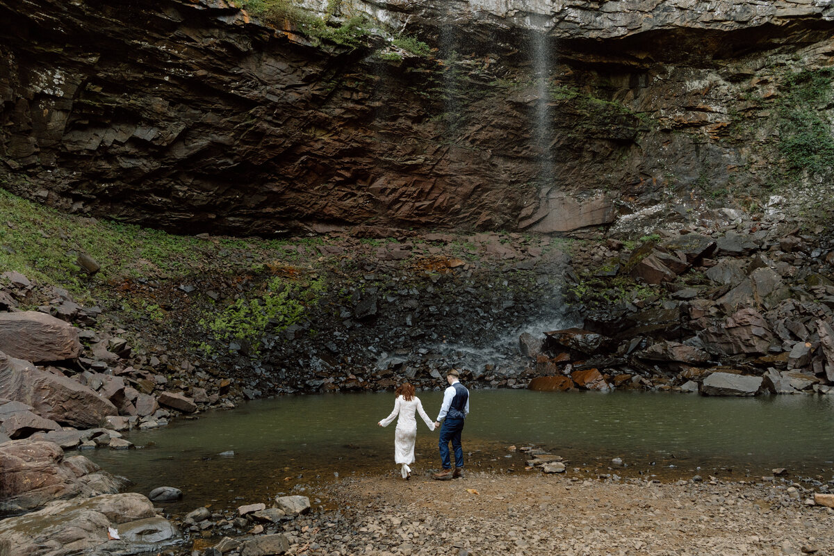 couple holding hands at elopement at fall creek falls in tennessee