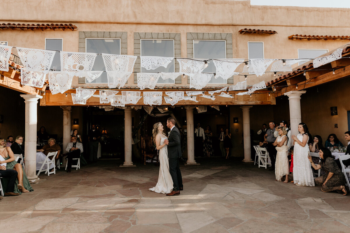 bride and grooms first dance in an outdoor courtyard