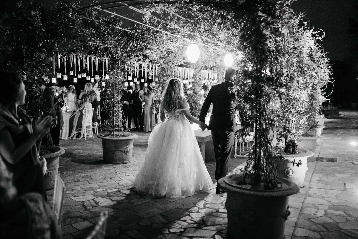 Bride and groom entering the evening reception at Castello di SEgalari