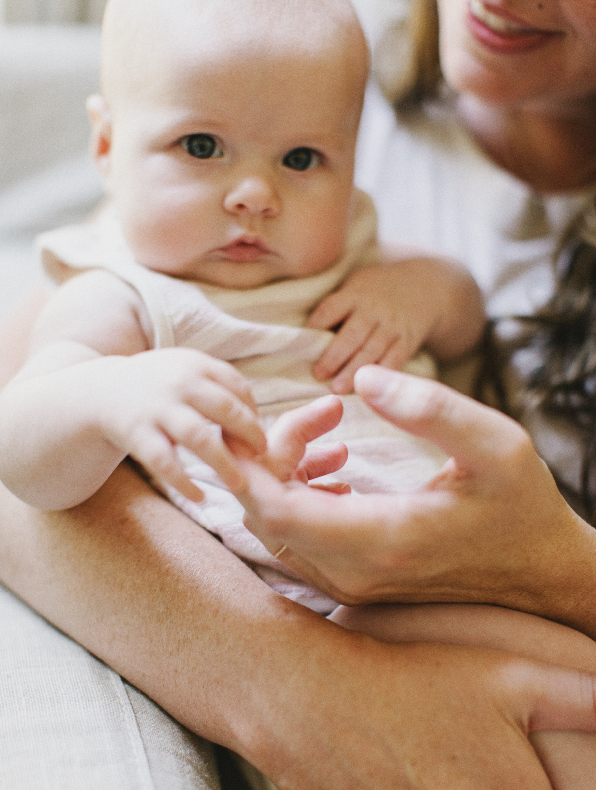 mother and newborn daughter holding hands