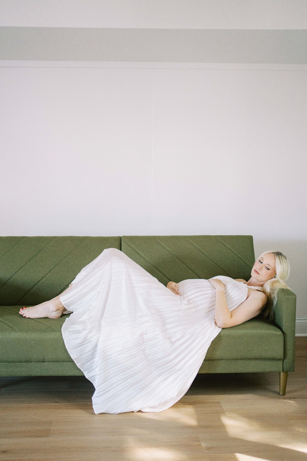 pregnant mom laying on couch touching belly