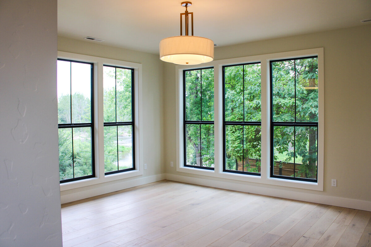 empty living space with ceiling to floor windows with black trim
