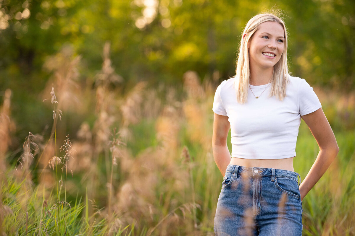Ottawa family photography of a blonde teenage daughter smiling in a grassy field at sunset golden hour