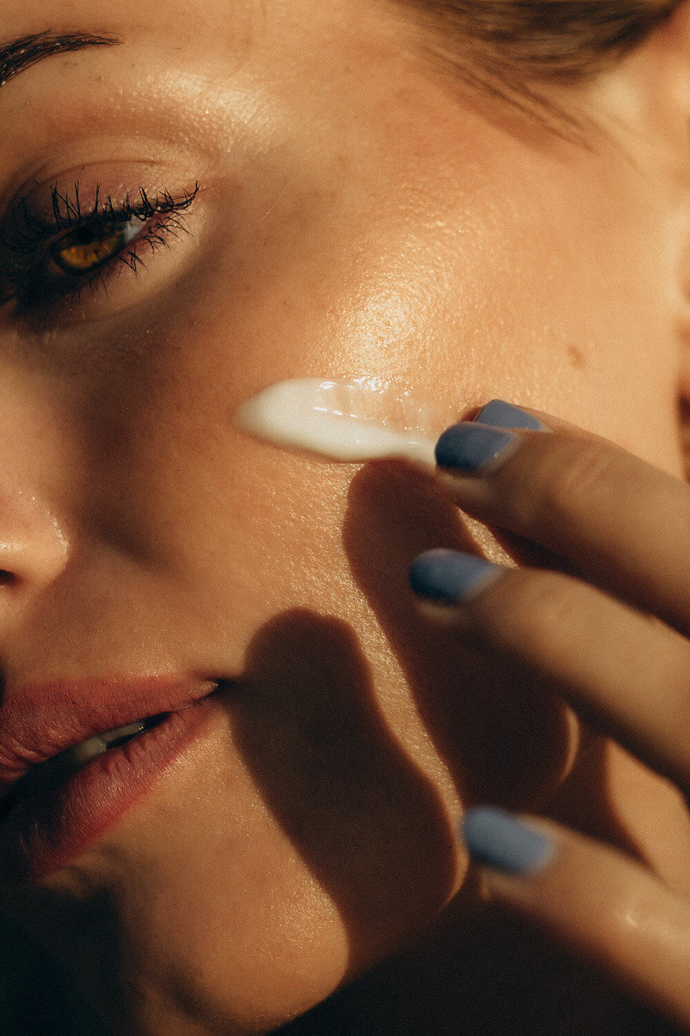 Closeup of a model applying skin location in the sun during a brand photoshoot for fake tanning company.