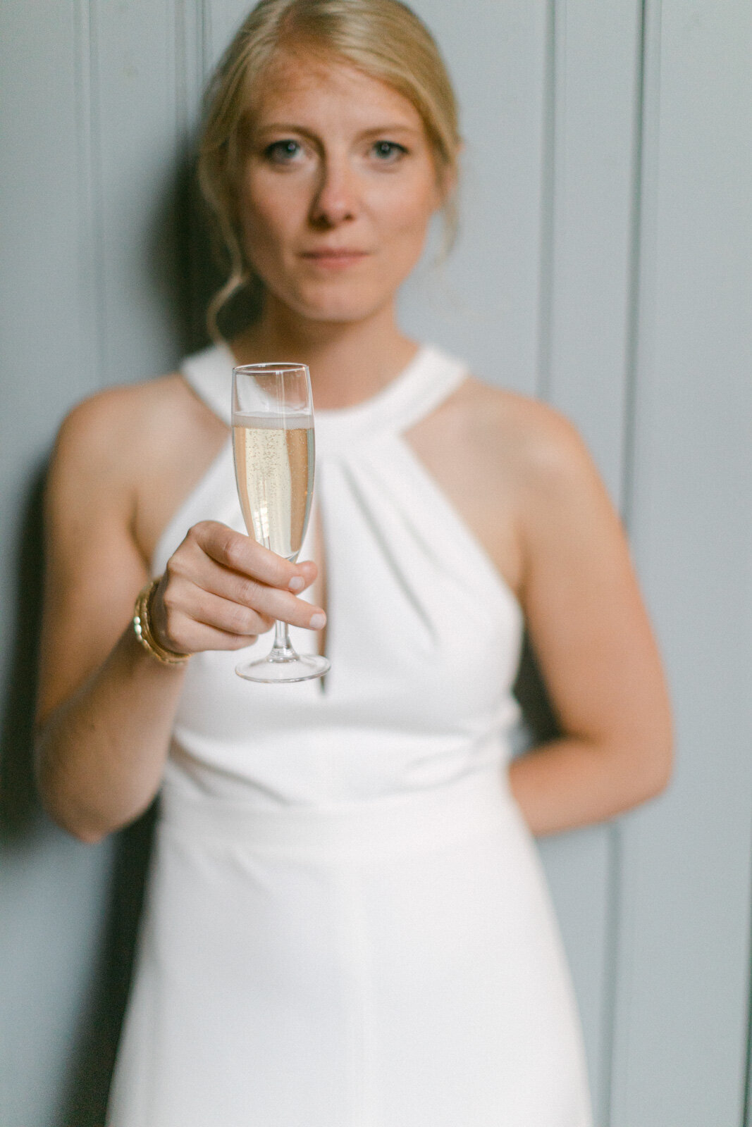 Mariée tenant une coupe de champagne pendant une réception de mariage élégante à Nantes.