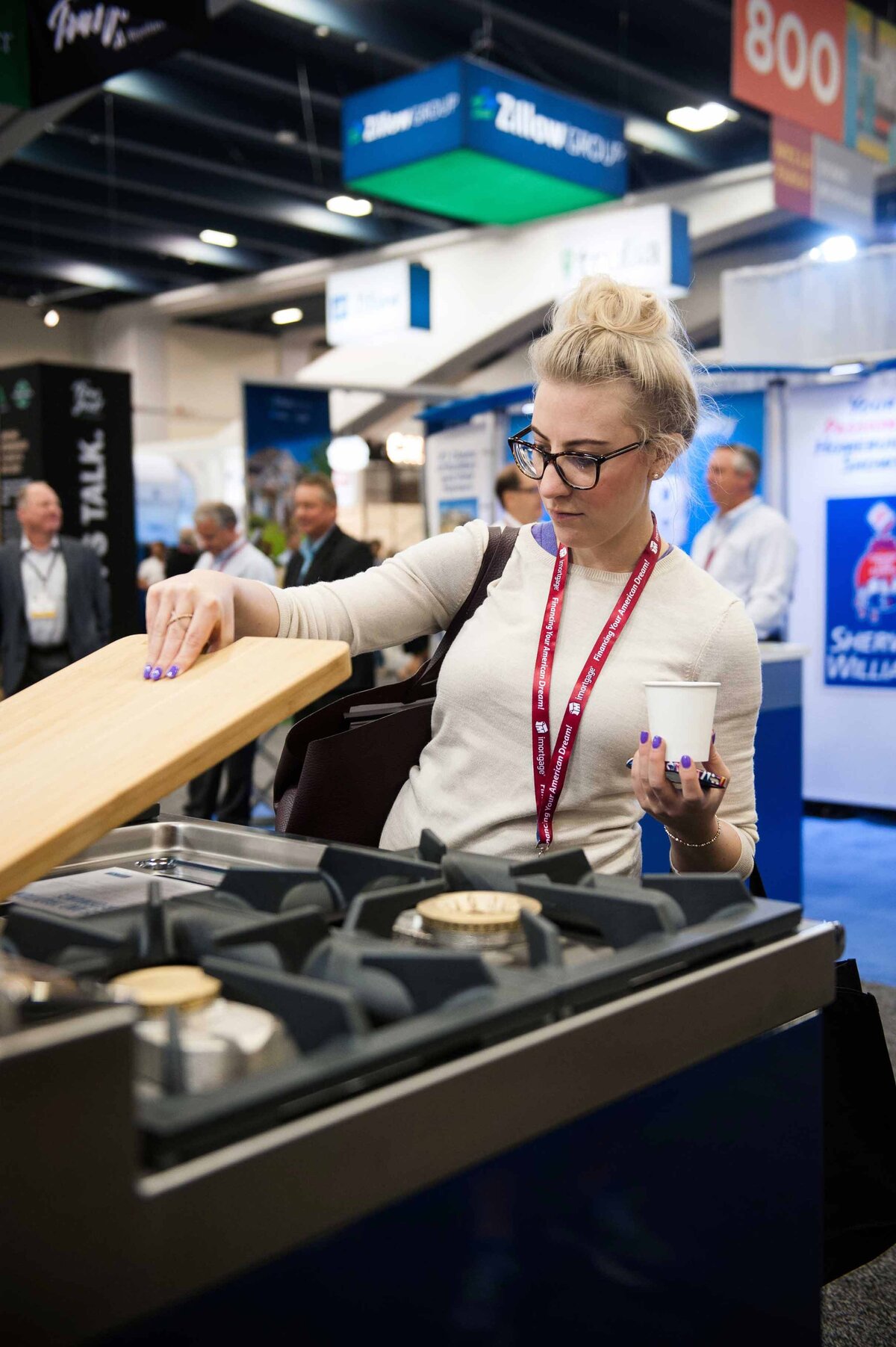 Women picks up a piece of a stovetop as she shops the showroom floor