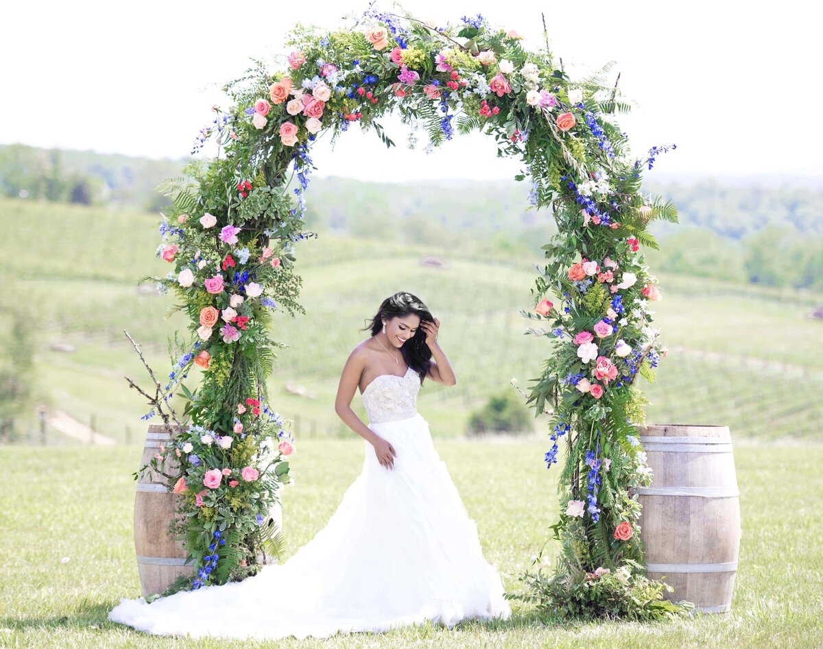Bride under floral arch