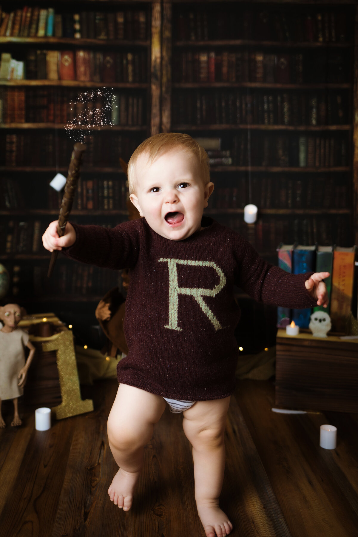Cake Smash Photographer, a baby wears a sweater with an R resembling ron weasley from Harry Potter Movies, he holds a wand