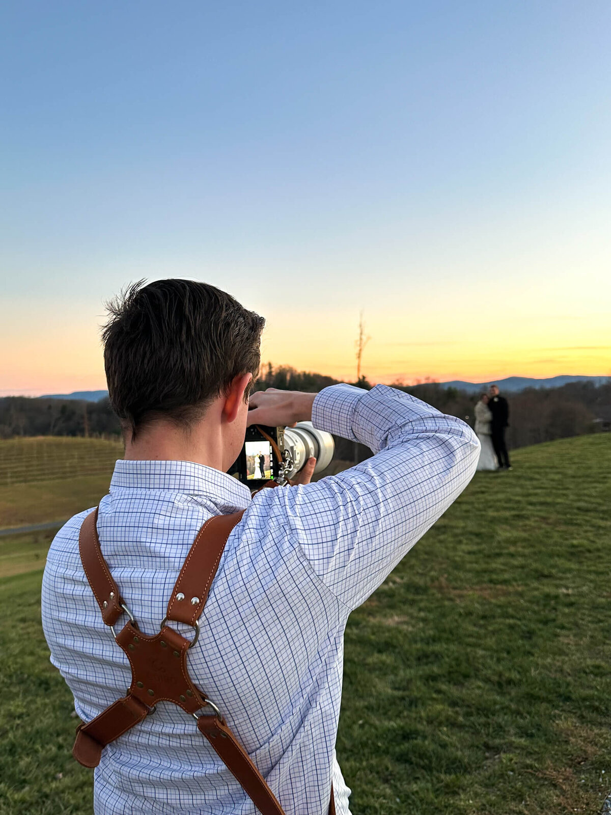 Photo of Michael Fricke, owner of Michael Fricke Photography, capturing a wedding couple during their sunset portrait session on their wedding day