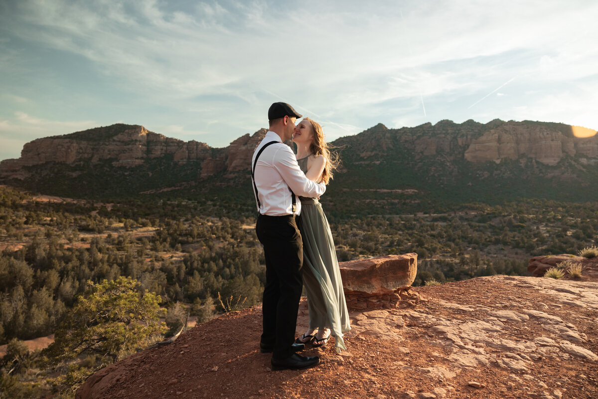 Couple standing against red rock backdrop during Sedona engagement session