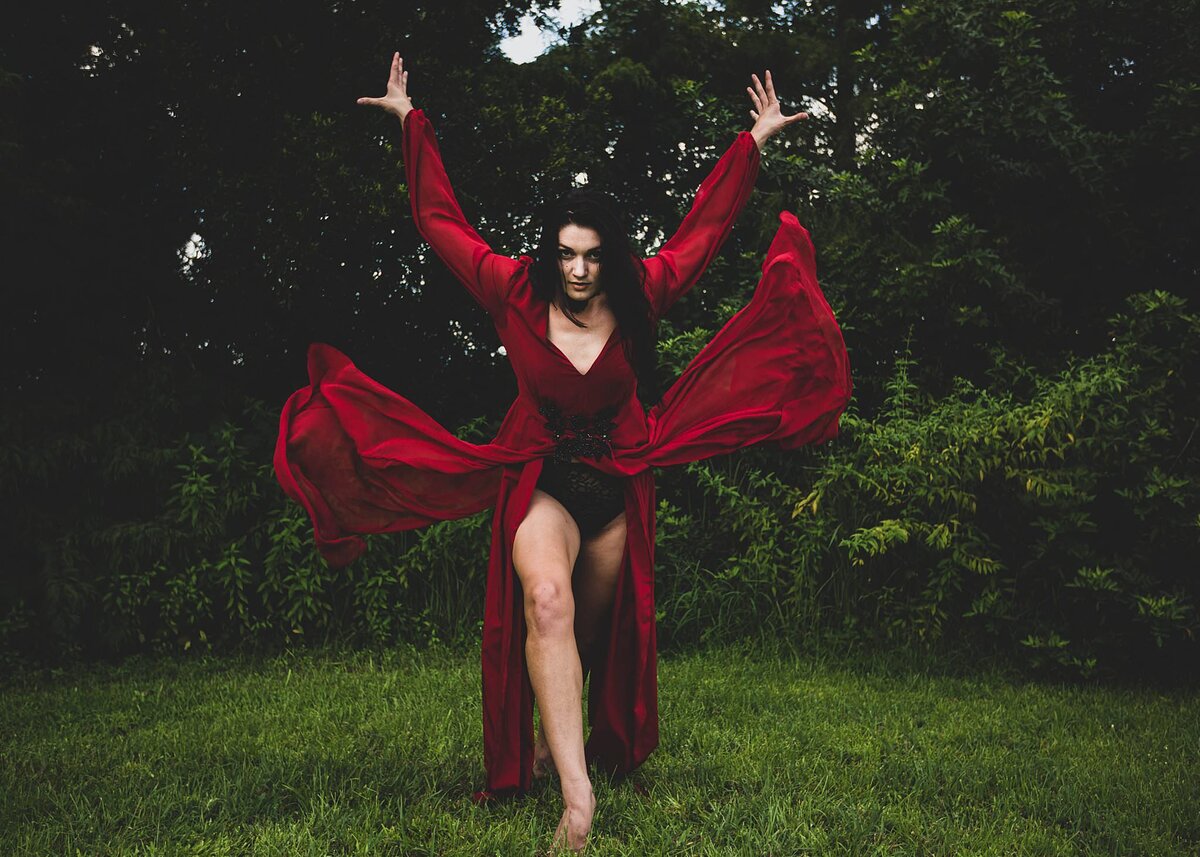 Dancer with long flowy red dress in the woods  passionate and free