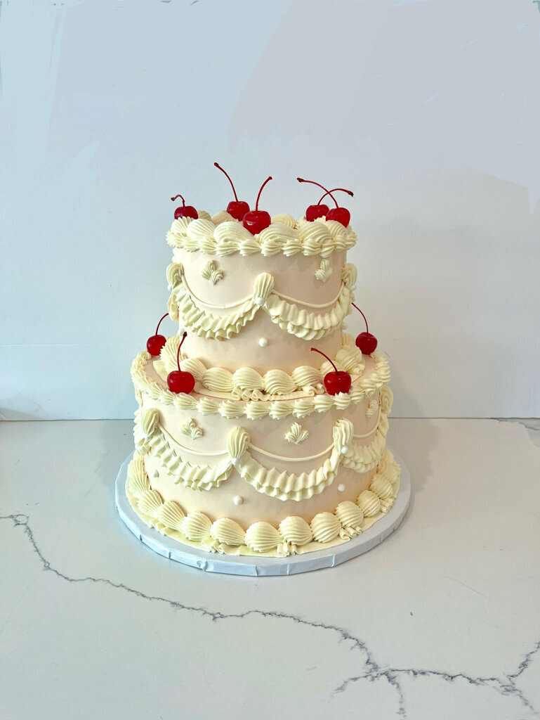 Vintage style 2-tier wedding cake topped with cherries by Bake My Day, contemporary cakes & desserts in Calgary, Alberta, featured on the Brontë Bride Vendor Guide.