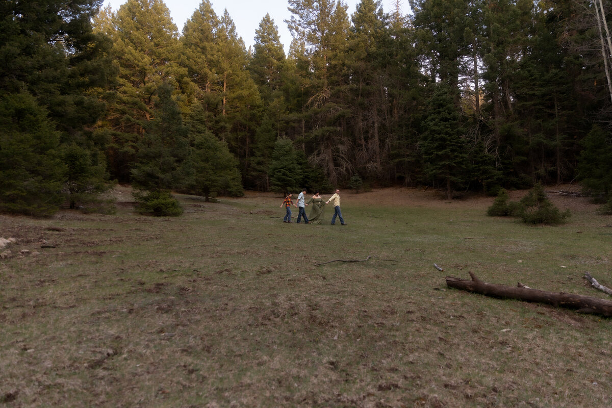 Family enjoying a photo session in a forest setting in Utah, captured by Lamblight Photography