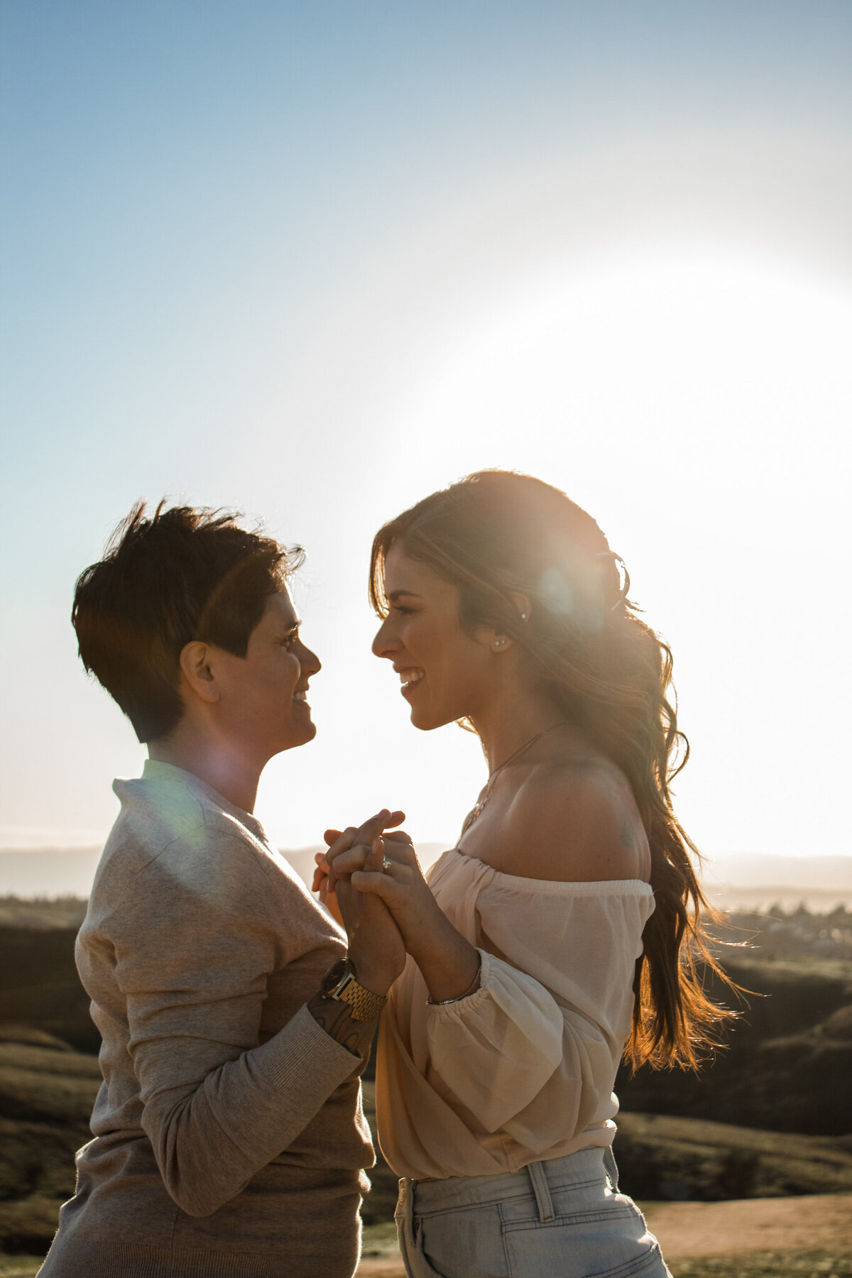 queer couple hold hands in phoenix sunset