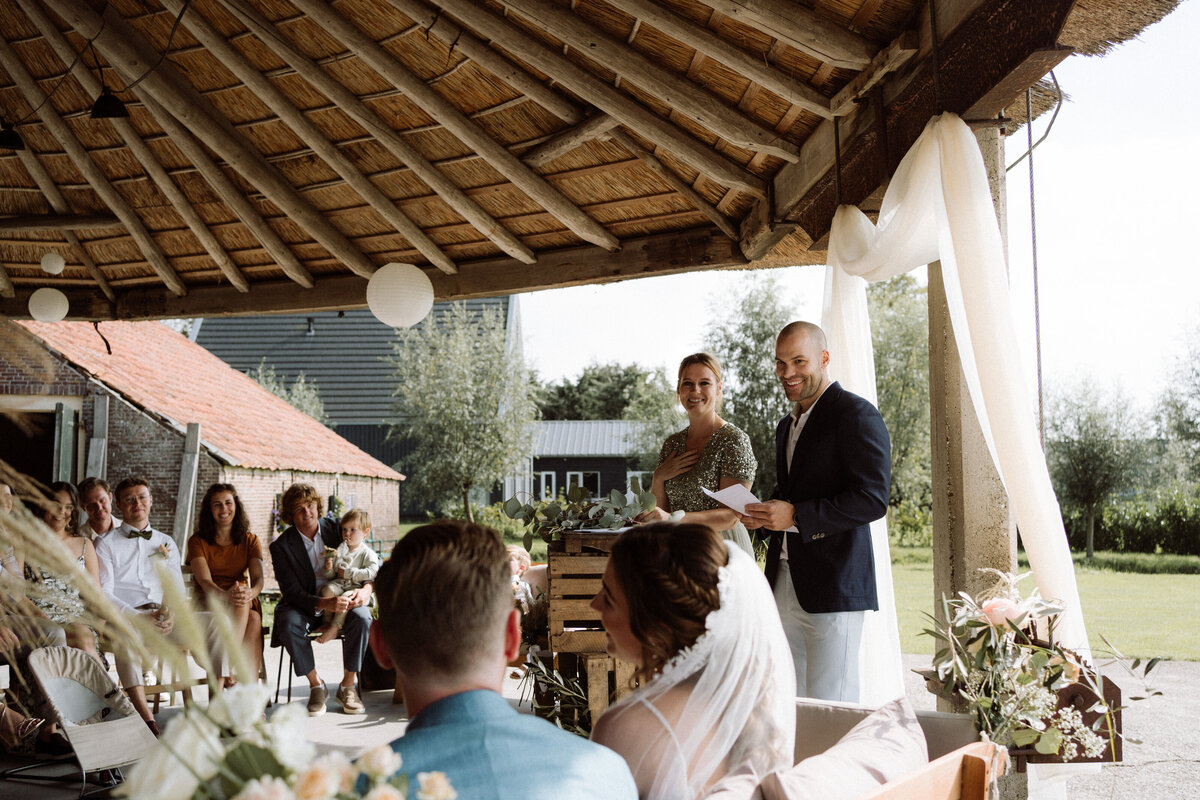 Sfeervolle bruiloft bij Nigtevecht Freeland Farm, met een persoonlijk aangekleed decor en het bruidspaar dat geniet van een lange borrel in een gezellige, intieme sfeer. Ceremonie onder de hooiberg. 
