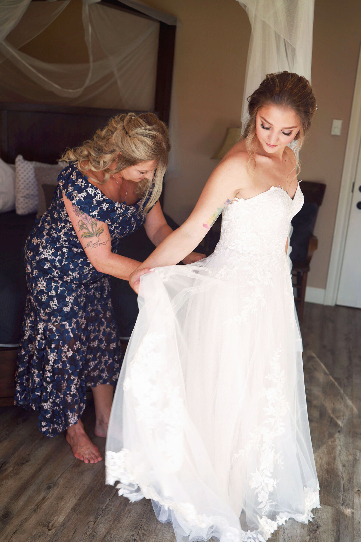 A mother helps bustle her daughters wedding dress, on a beautiful Sunday afternoon in Aspen, Colorado,