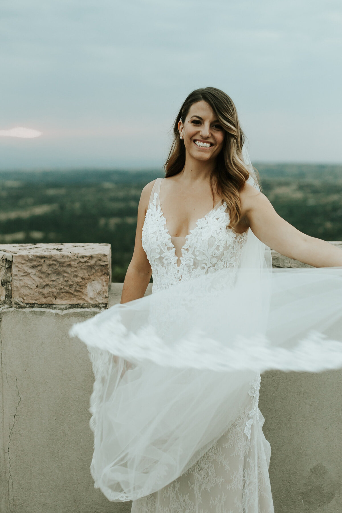 Bride in lace dress and lace veil on her wedding day in Colorado.