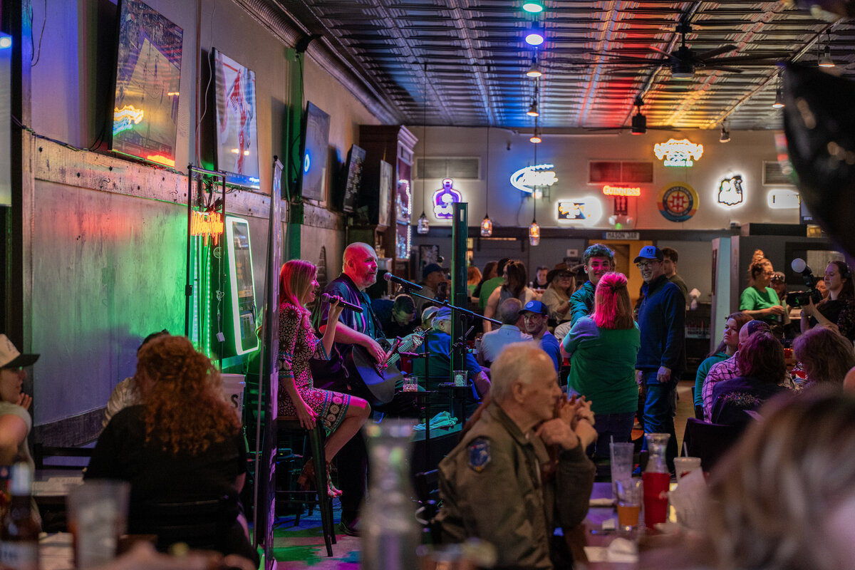 A small bar with two people playing music 