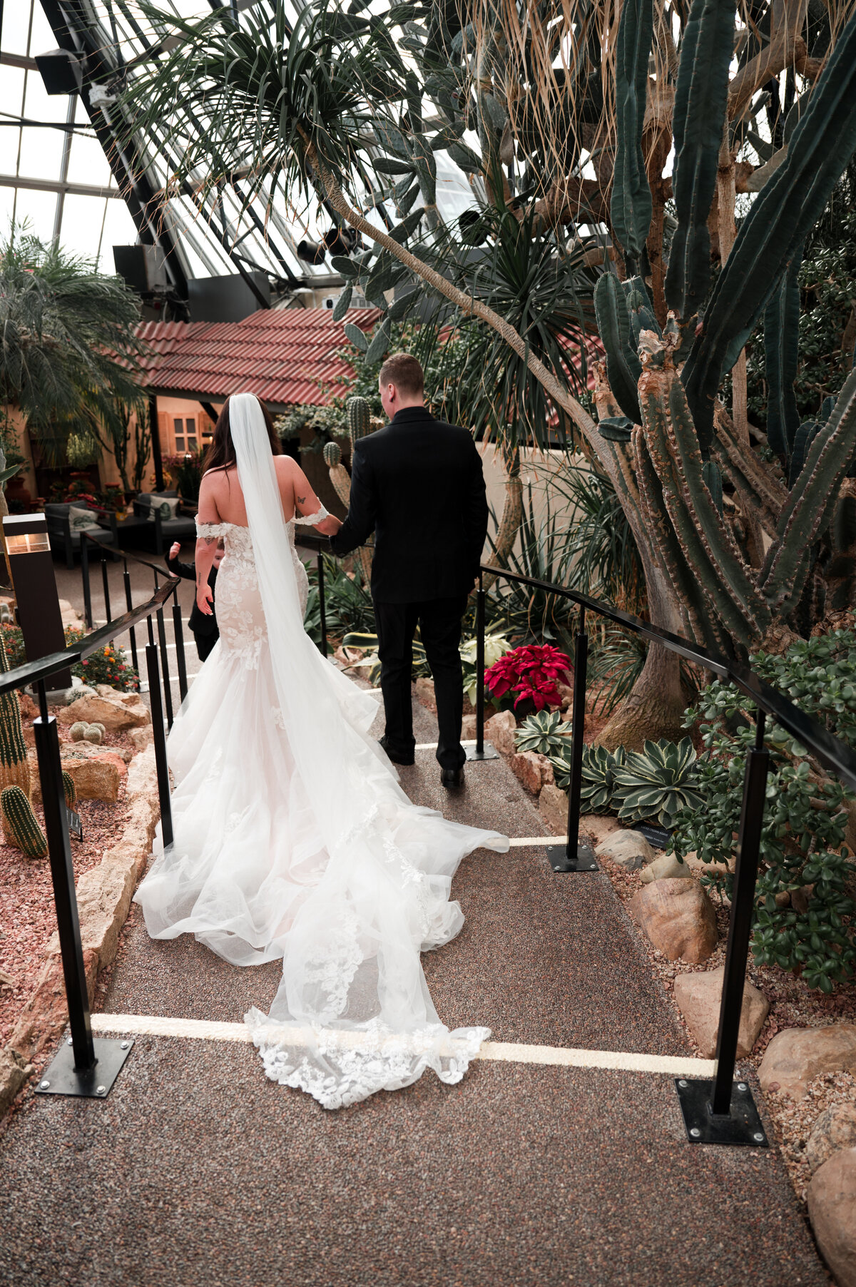 bride and groom walking down stairway in the desert greenhouse pyramid at the Muttart Conservatory