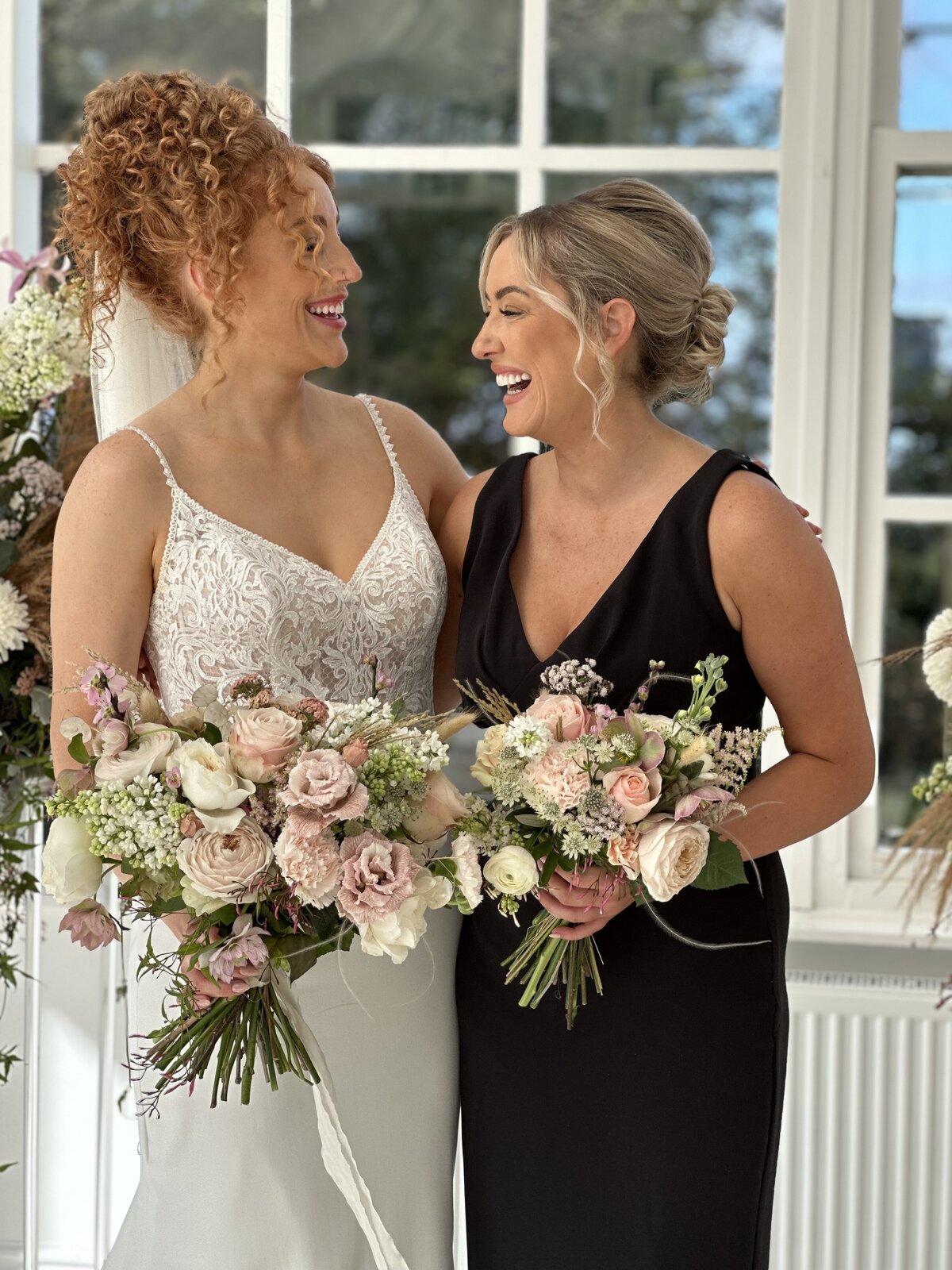 two sisters candidly laughing at a wedding