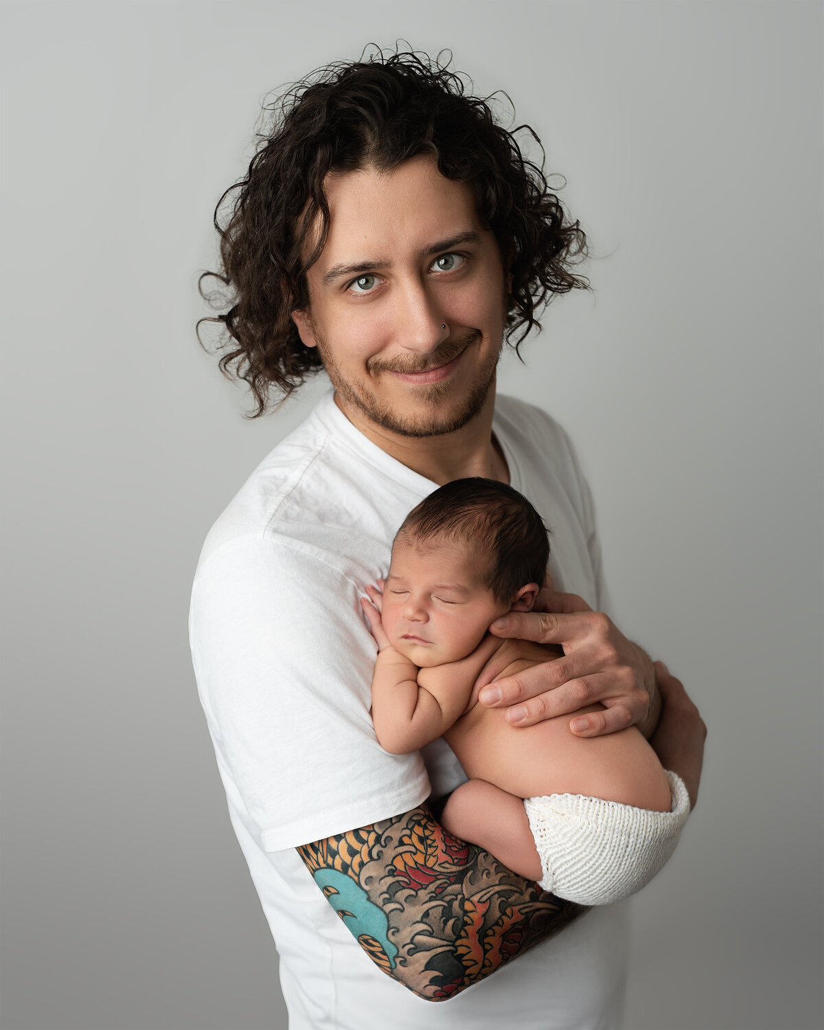 Studio family portrait of father gently cradling newborn | Paris Ontario photographer