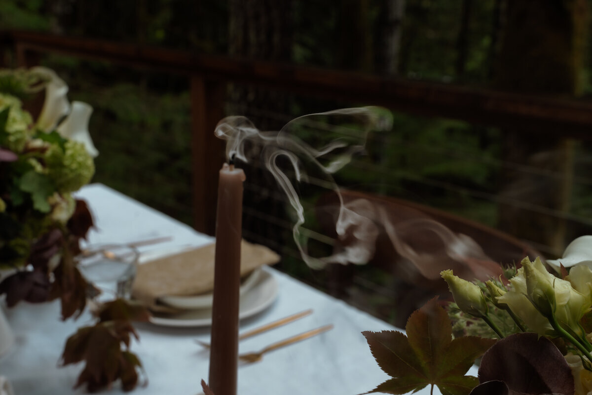 Candle blown out as wedding coordinators clean up an intimate wedding dinner in Bend, Oregon