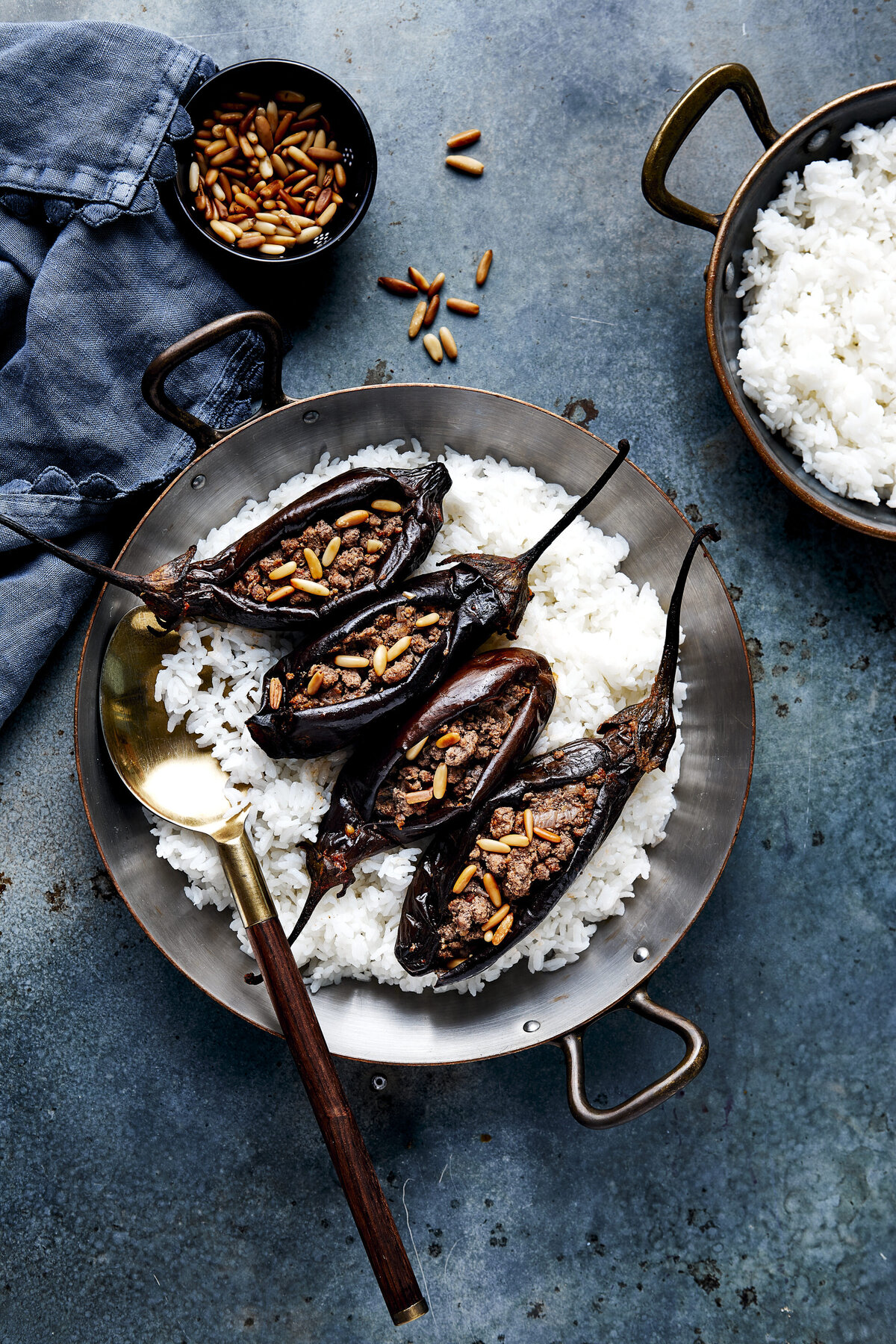 A metal wok with roasted eggplant and rice in it.