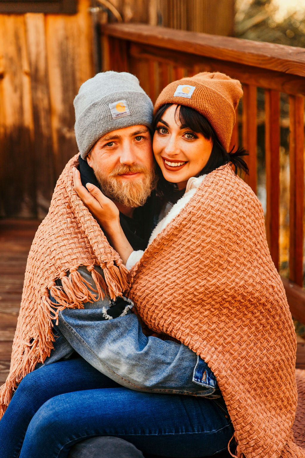 husband and wife under blanket outside