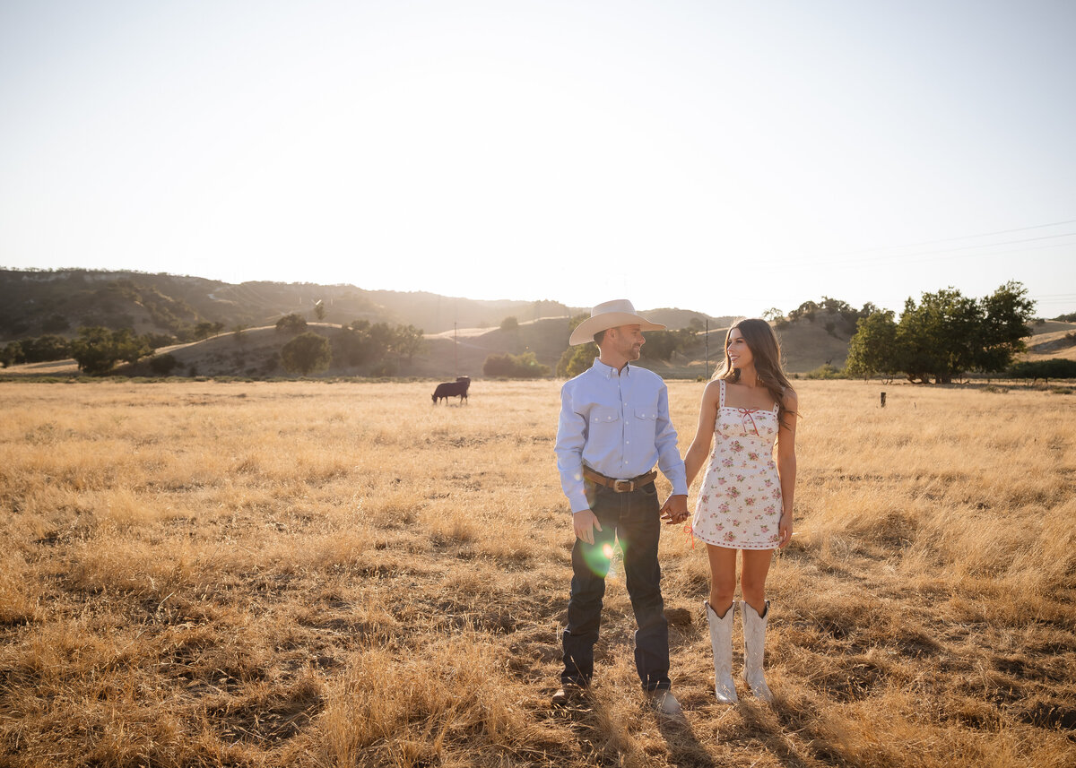 candid couples engagement photos in golden hour field in San Luis Obispo on the Central Coast