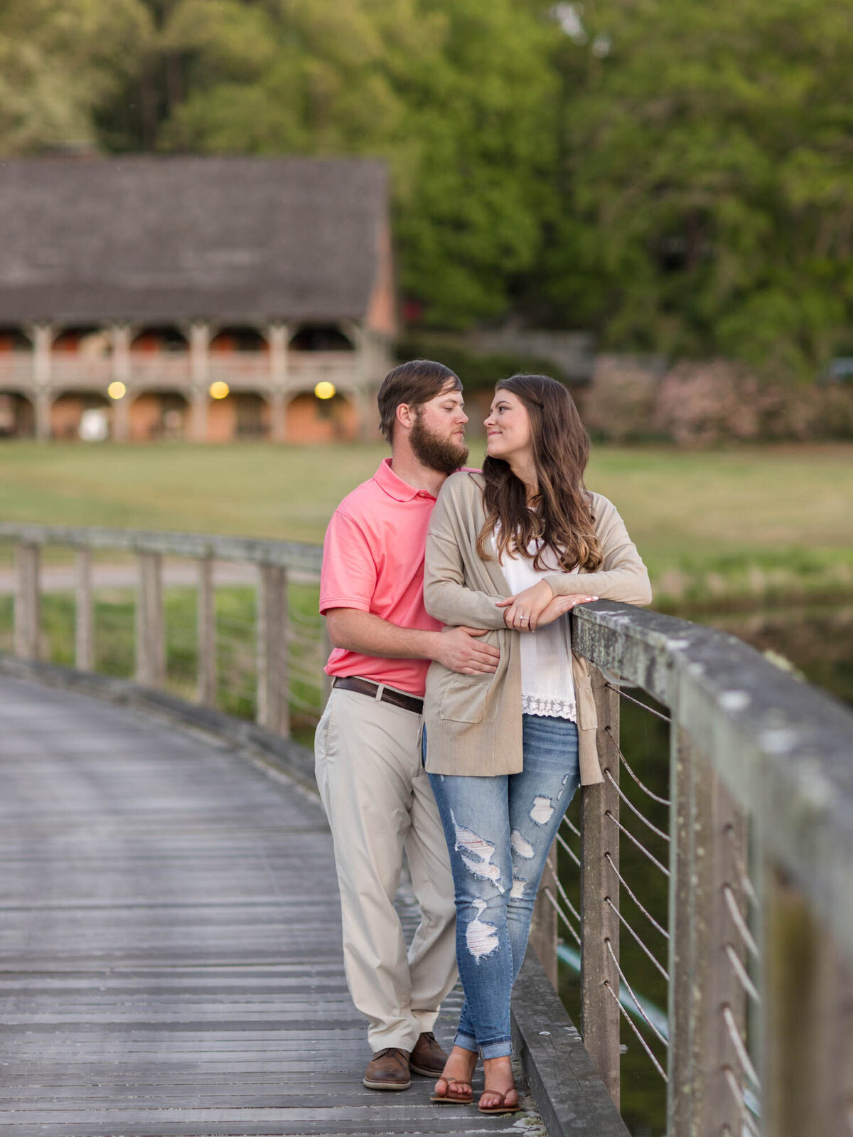 Couple on the dock at Callaway Gardens leaning against the railing about to share a kiss during their engagement portraits.