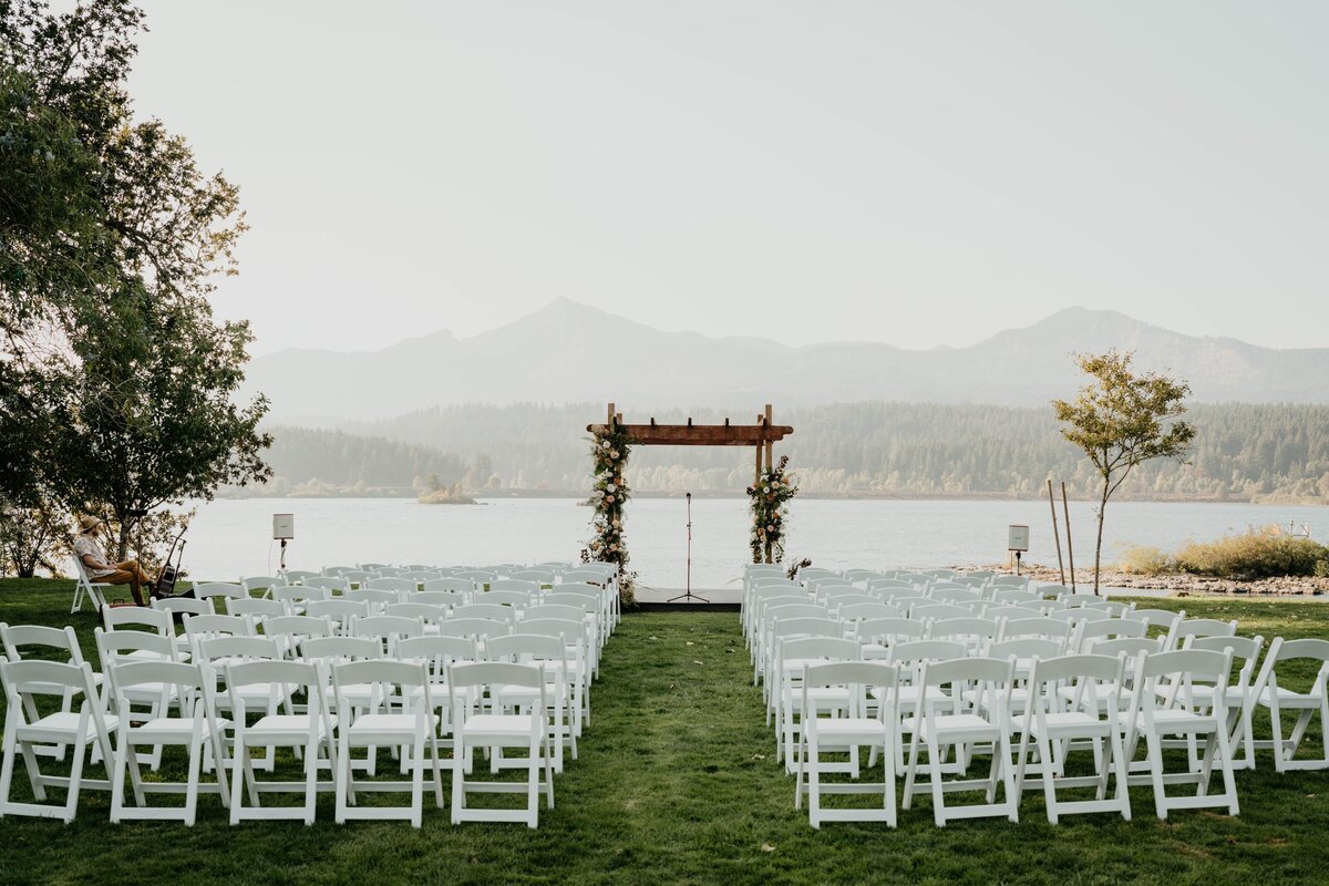 View of wedding ceremony in the grass before guests with views of the Columbia River Gorge