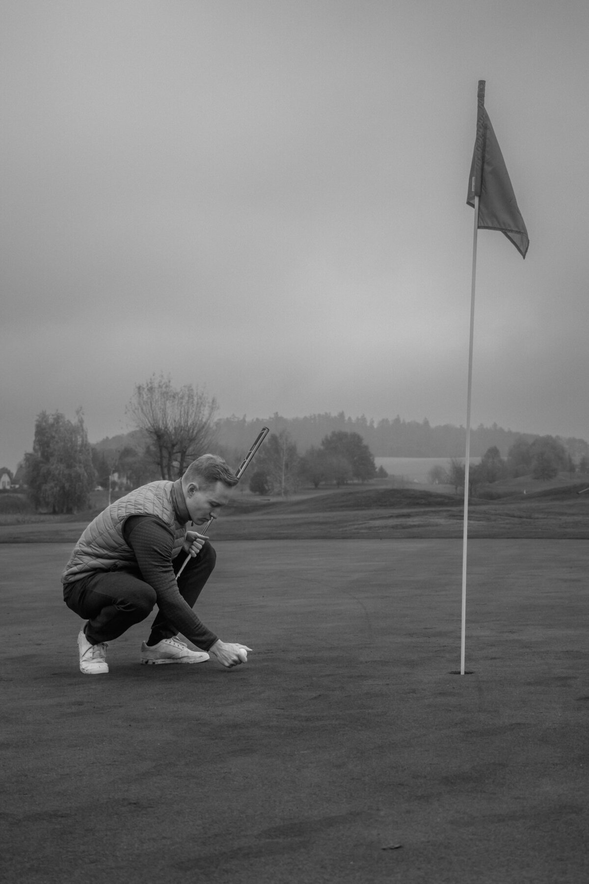 Black and white picture of the groom playing golf.