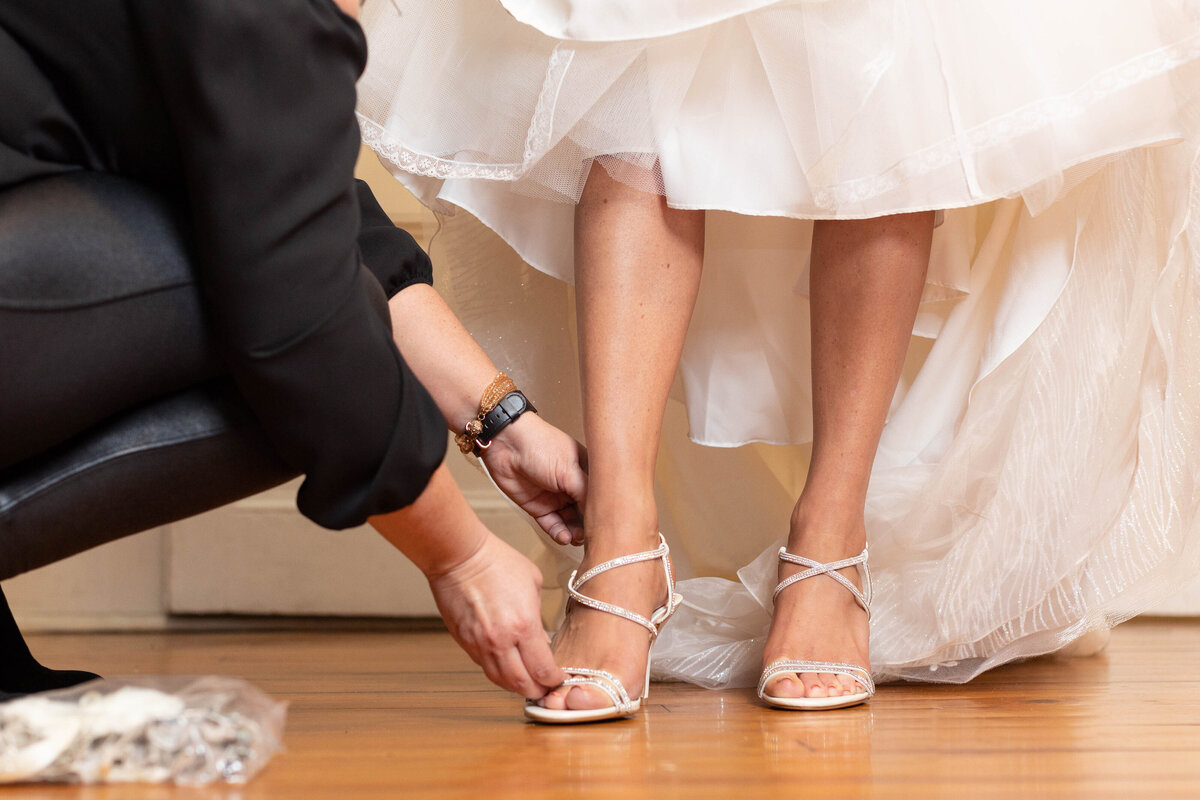 The bride adorns her shoes for the wedding day.