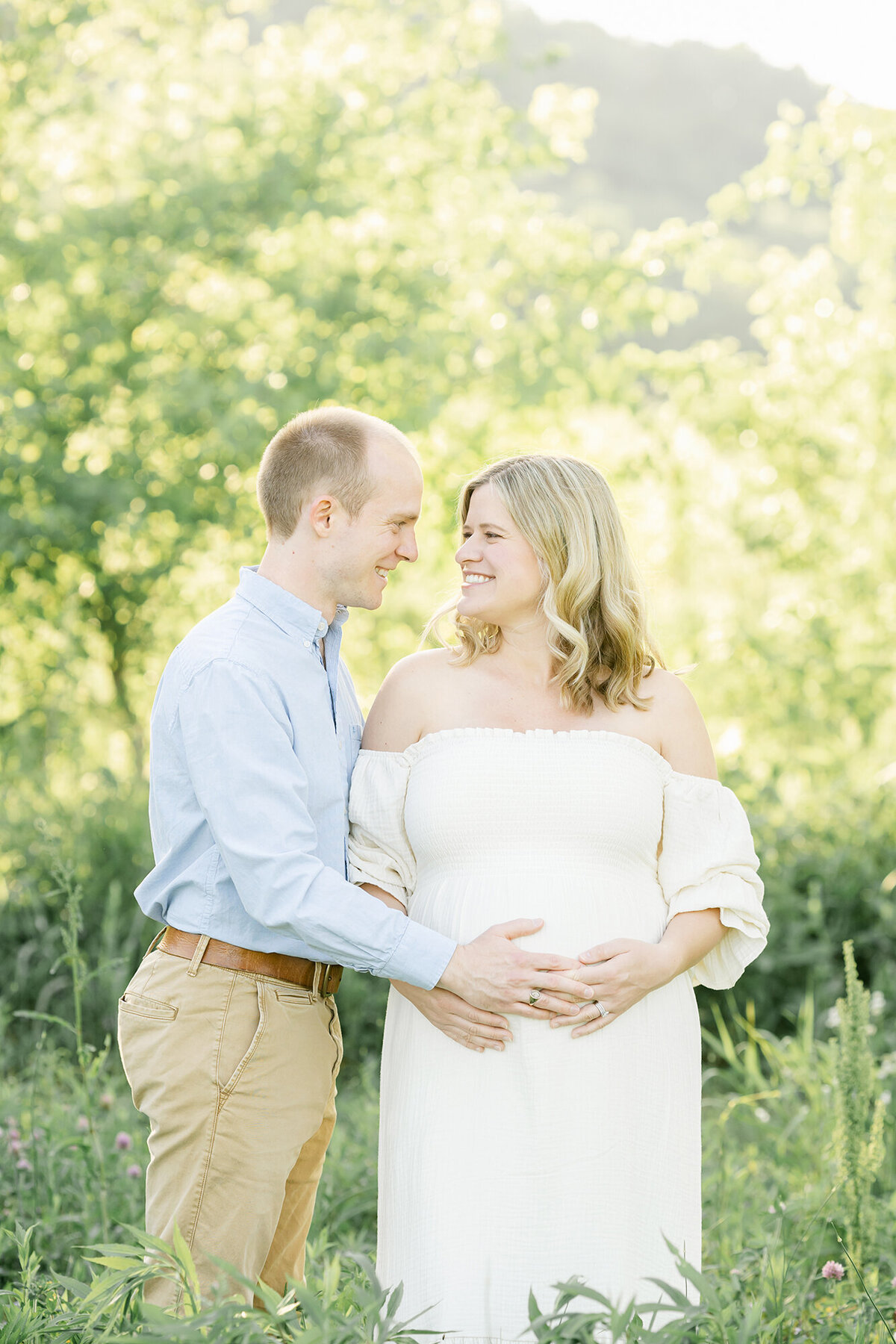 Pregnant couple poses in Louisville KY field during outdoor maternity photo shoot with Julie Brock Photography