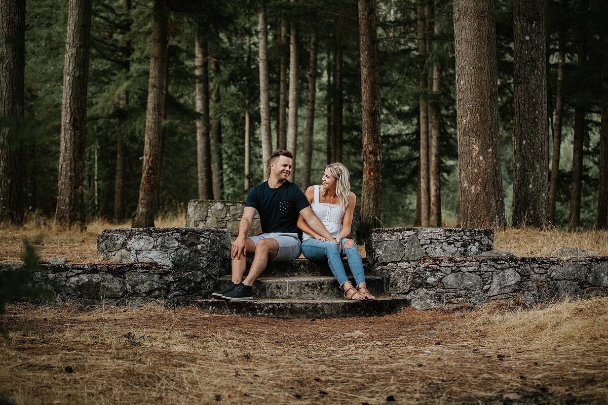 Couple sitting on rocks in forest