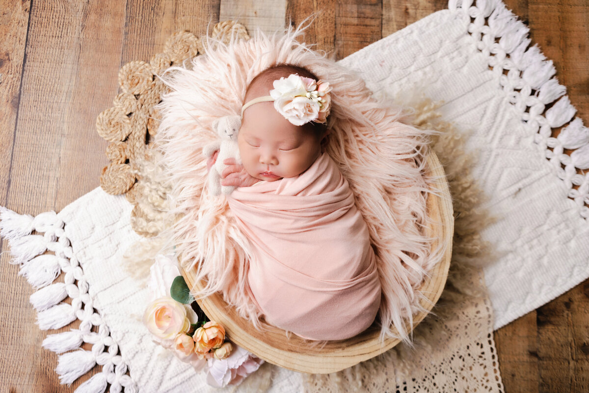 newborn girl wrapped in pink on pink shag blanket