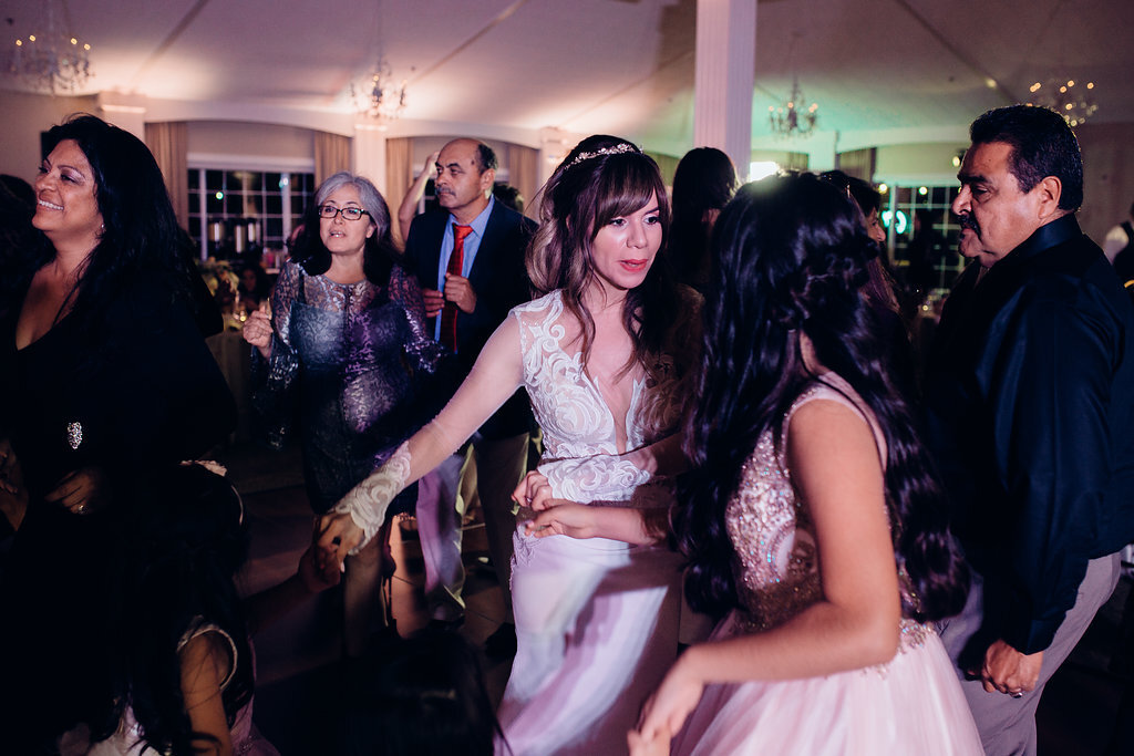 Wedding Photograph Of Bride Talking While Dancing With a Woman In White Dress Los Angeles