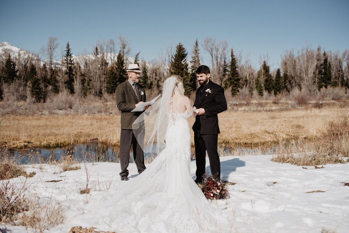 Jackson Hole Photographers capture bride and groom holding hands during ceremony