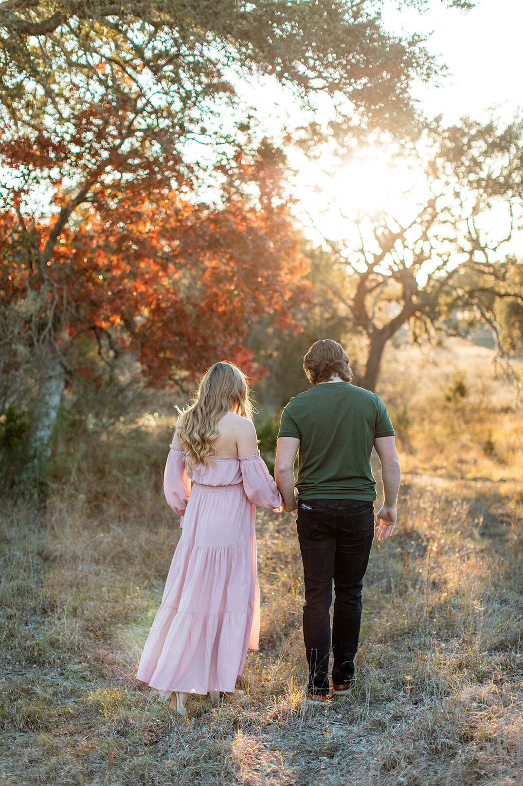 Maternity photo of a pregnant couple standing in a sunlit field, photographed by San Antonio family photographer Sara James.