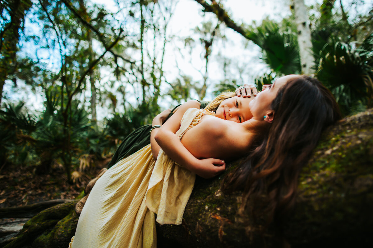 woodland style boho family portraits taken in tampa with cool trees that overhang the river