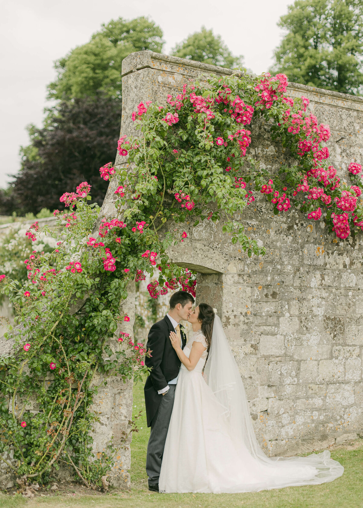 chloe-winstanley-weddings-wiltshire-hatch-house-couple-kiss-archway
