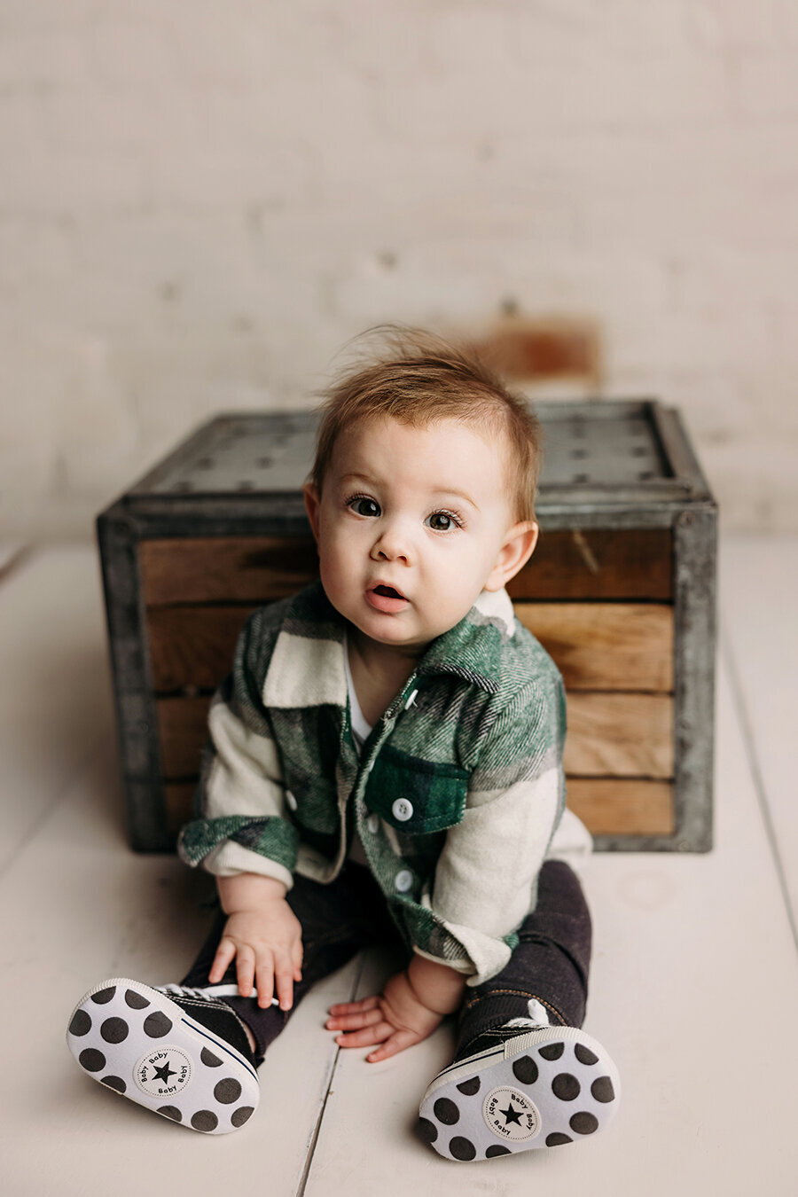 Fort Collins baby boy sitting in front of a box holding him up