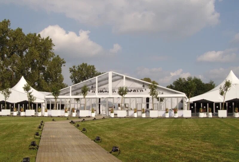 A large frame marquee with a long walkway and trees outside of the front
